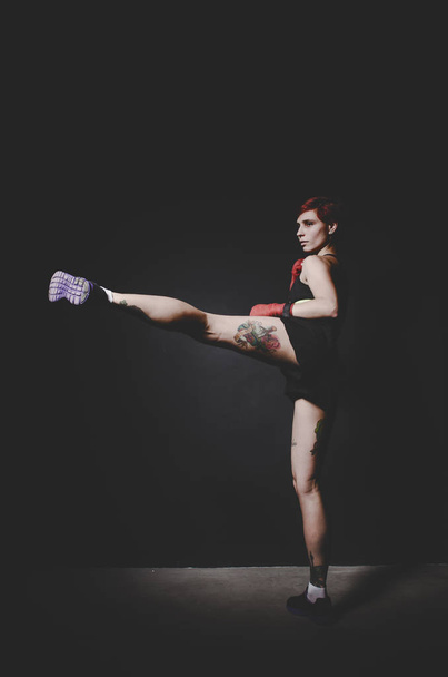 young tattooed woman boxer boxing with leg - Foto, immagini