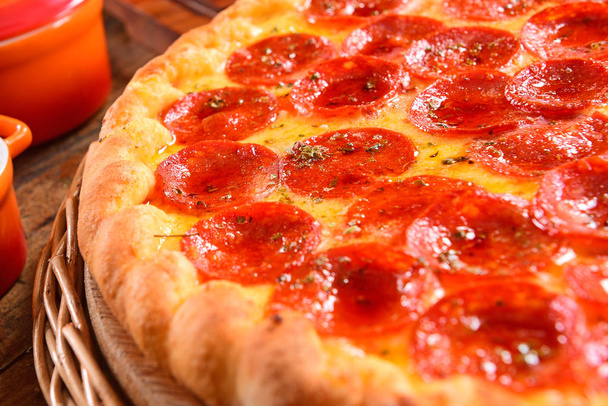pepperoni pizza na dřevěném pozadí - Fotografie, Obrázek