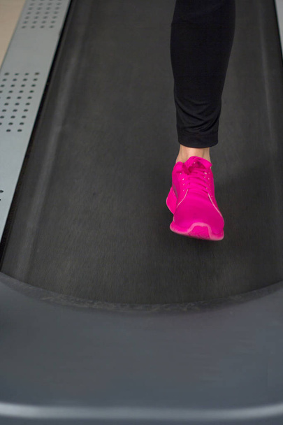 fit female legs on a treadmill at the gym - Foto, Bild