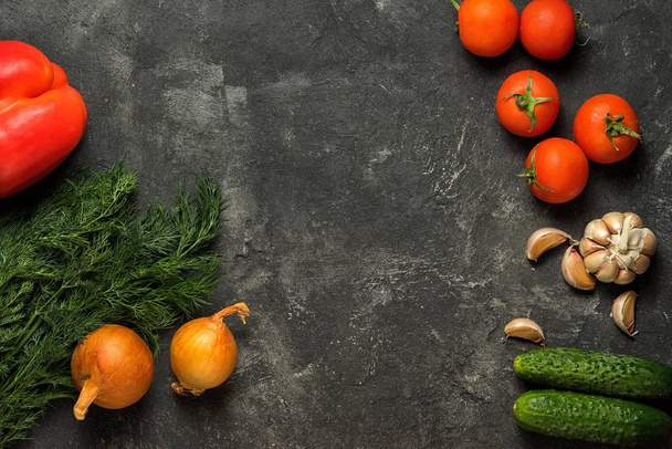 Food background. Raw vegetables on a dark black stone background, top view. Copy space in the middle. - Foto, imagen