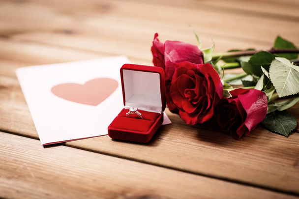 крупним планом алмазне кільце, троянди і вітальна листівка
 - Фото, зображення