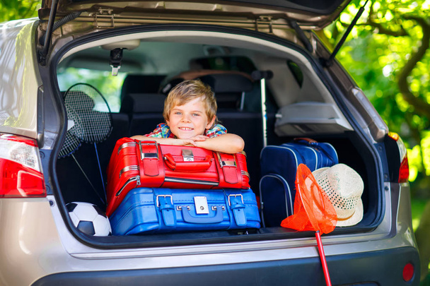 Little kid boy sitting in car trunk just before leaving for vaca - Foto, immagini