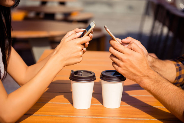 Gros plan de l'homme et de la femme tapant des sms et buvant du café
 - Photo, image