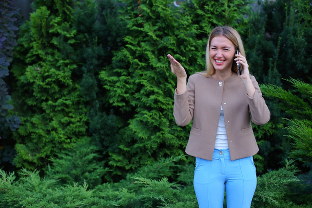 Ελκυστική ξανθιά κυρία που μιλάει στο τηλέφωνο και κρατά στο χέρι, smi - Φωτογραφία, εικόνα