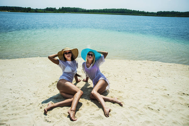 women sitting on white hot sand - Photo, image