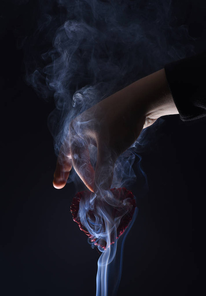 male hand with decorative valentines day red heart in smoke - Foto, Imagem