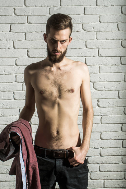 slim bearded man with thin bare torso on brick background - Zdjęcie, obraz