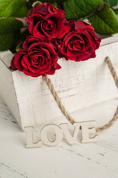 Rosas rojas flores con palabra de madera AMOR
 - Foto, Imagen