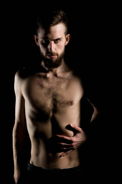 slim bearded man with thin bare torso isolated on black - Foto, Imagem