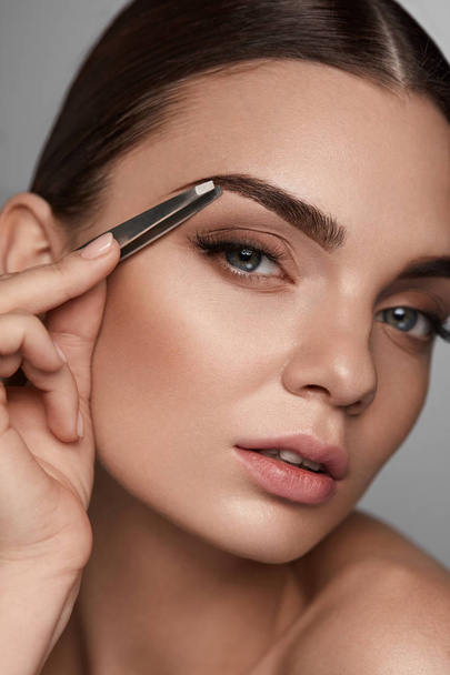 Beautiful Woman Plucking Eyebrows. Beauty Brows Correction - Photo, Image