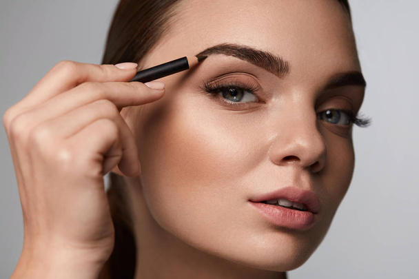 Beautiful Woman Contouring Eyebrows With Pencil. Beauty  - Фото, зображення