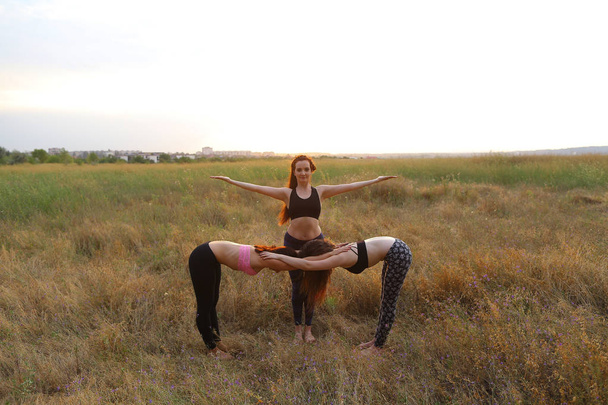 Femmina praticare yoga in piedi in posa, due ragazze piegate e gras
 - Foto, immagini