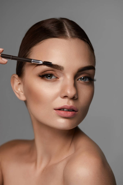 Beautiful Woman Brushing Eyebrows With Brow Tool - Foto, immagini