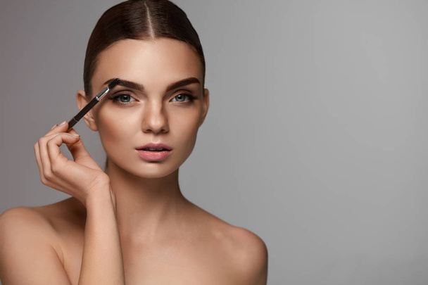 Beautiful Woman Brushing Eyebrows With Brow Tool - Valokuva, kuva