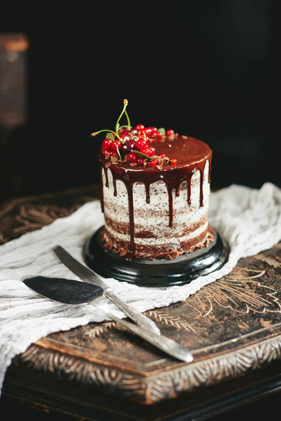 Čokoládový dort s červených bobulí rybízu na starý dřevěný stůl - Fotografie, Obrázek
