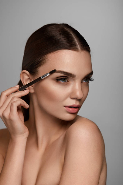 Beautiful Woman Brushing Eyebrows With Brow Tool - Zdjęcie, obraz