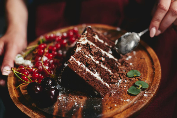 Kobieta jedzenie ciasto czekoladowe z jagody czerwone porzeczki - Zdjęcie, obraz