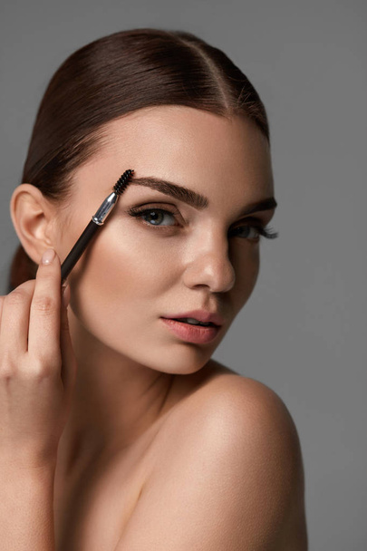 Beautiful Woman Brushing Eyebrows With Brow Tool - Fotografie, Obrázek