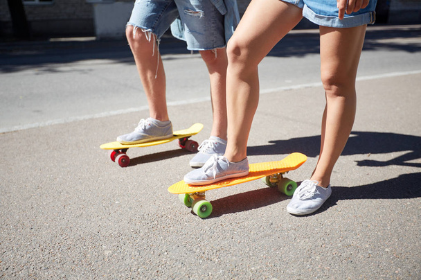 teenage couple riding skateboards on city street - Фото, зображення