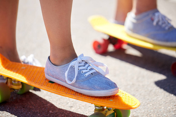 close up of feet riding skateboards on city street - Fotoğraf, Görsel