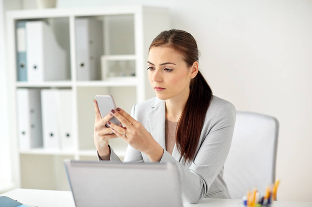businesswoman with smartphone at office - Photo, image