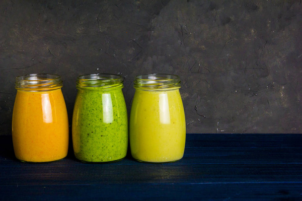 Healthy colorful fruit smoothie set on a dark background - Photo, image