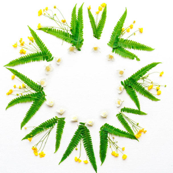 Wreath with jasmine ranunculus and leaves of green fern - Foto, imagen