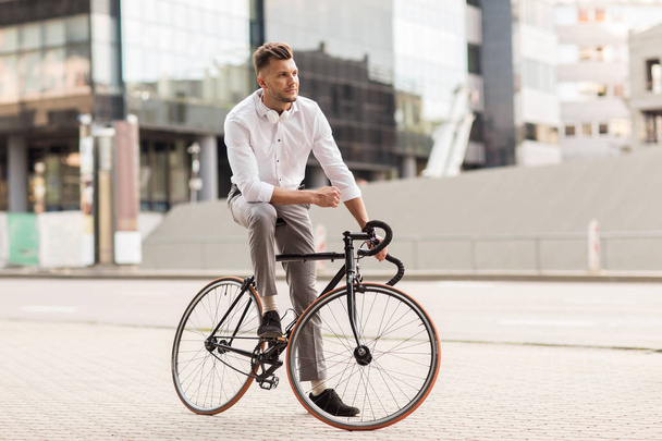 man with bicycle and headphones on city street - Фото, зображення