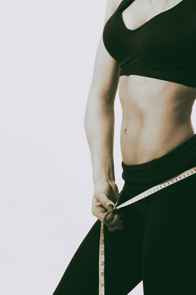 Fitness. Sports figure of a girl on a light background. - Foto, Bild