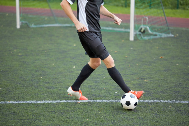 soccer player playing with ball on football field - Foto, afbeelding