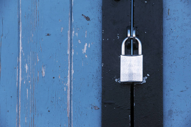 Silver padlock on an old blue wooden door, concept background - Foto, Imagem