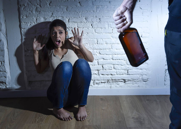 Alkoholisierter Mann greift Frau oder Ehefrau bei häuslicher Gewalt mit Flasche an - Foto, Bild