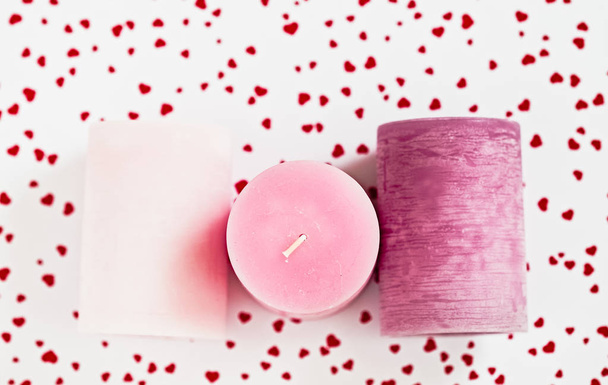 Три розовые свечи на красном сердечном фоне
  - Фото, изображение