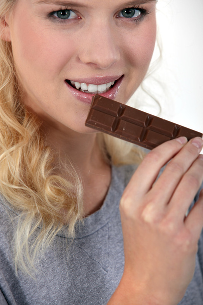 Vrouw die chocolade eet - Foto, afbeelding