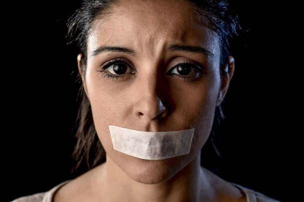 close up portrait of young attractive woman with mouth and lips sealed in adhesive tape restrained - Photo, Image
