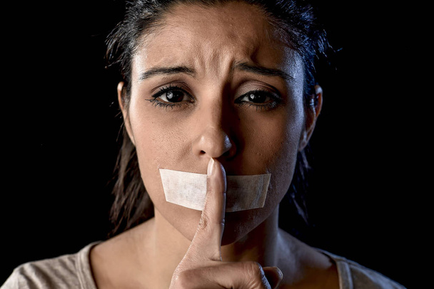 Portret van jonge aantrekkelijke vrouw met mond en lippen verzegeld in plakband ingetogen close-up - Foto, afbeelding