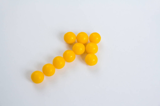 Vitamin C capsules in the form of arrow on white background - Foto, afbeelding
