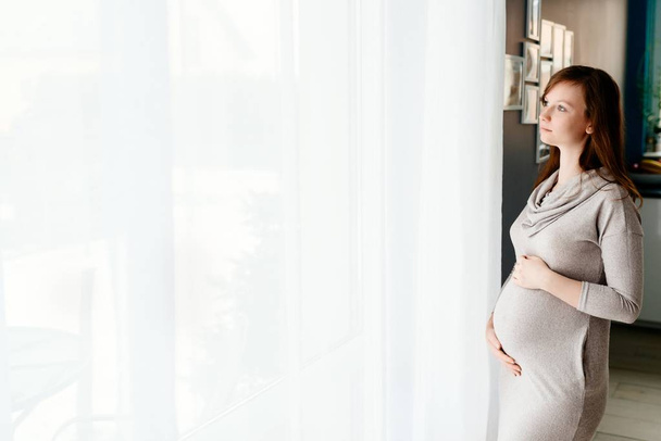 Pregnant woman in grey dress - Photo, Image