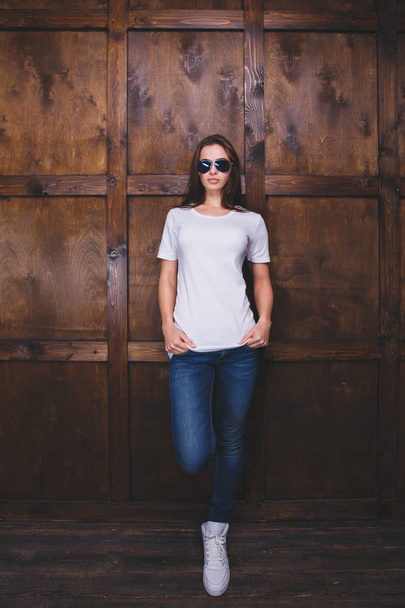 Mujer vistiendo camiseta blanca delante de la pared de madera
 - Foto, Imagen
