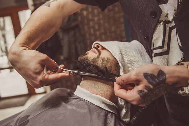 man shaving his beard in the professional hairdresser - Photo, Image