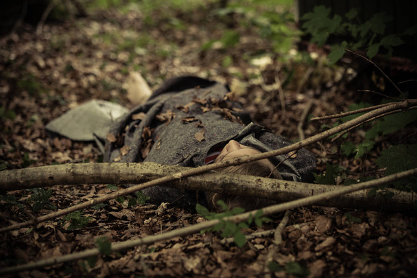 Cadáver adolescente cubierto de hojas
 - Foto, Imagen