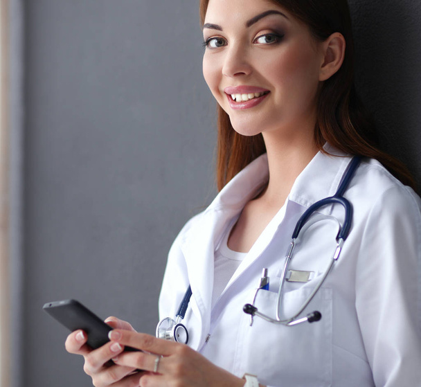 Young woman doctor sitting with your phone - Foto, Imagen