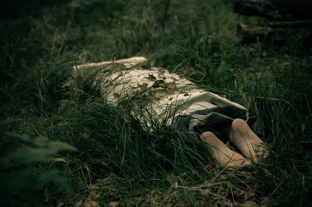 Víctima de asesinato envuelta en sábanas en el campo
 - Foto, imagen
