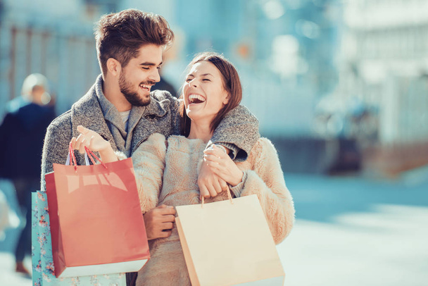 hermosa pareja amorosa joven llevando bolsas de compras - Foto, Imagen