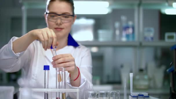 Vrouwelijke wetenschapper werken in chemische laboratorium. Wetenschapper sluiten reageerbuisjes - Video