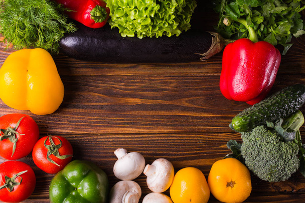 Different organic vegetables on a wooden background. Healthy eat - Photo, Image