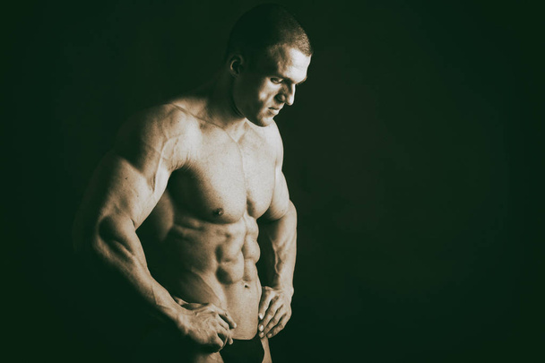 bodybuilder  on a dark background. - Photo, Image