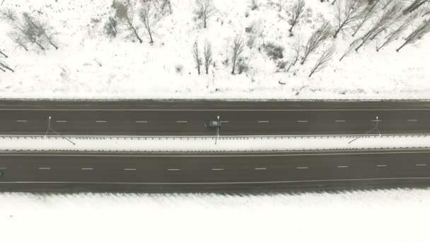  4k luchtfoto. Voorstad snelweg met auto in bewolkt winterdag. Laterale lage vlucht - Video