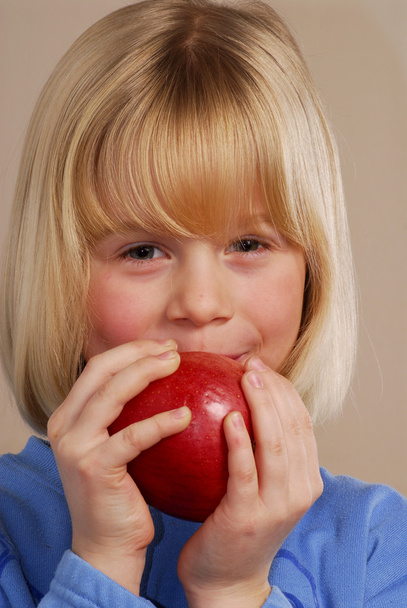 Little girl holding a red apple,little kid eating an apple. - Fotó, kép
