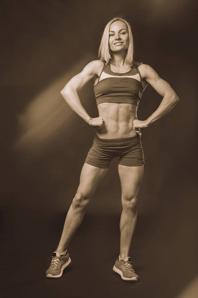 Professional fitness athlete on a dark background. - Photo, Image